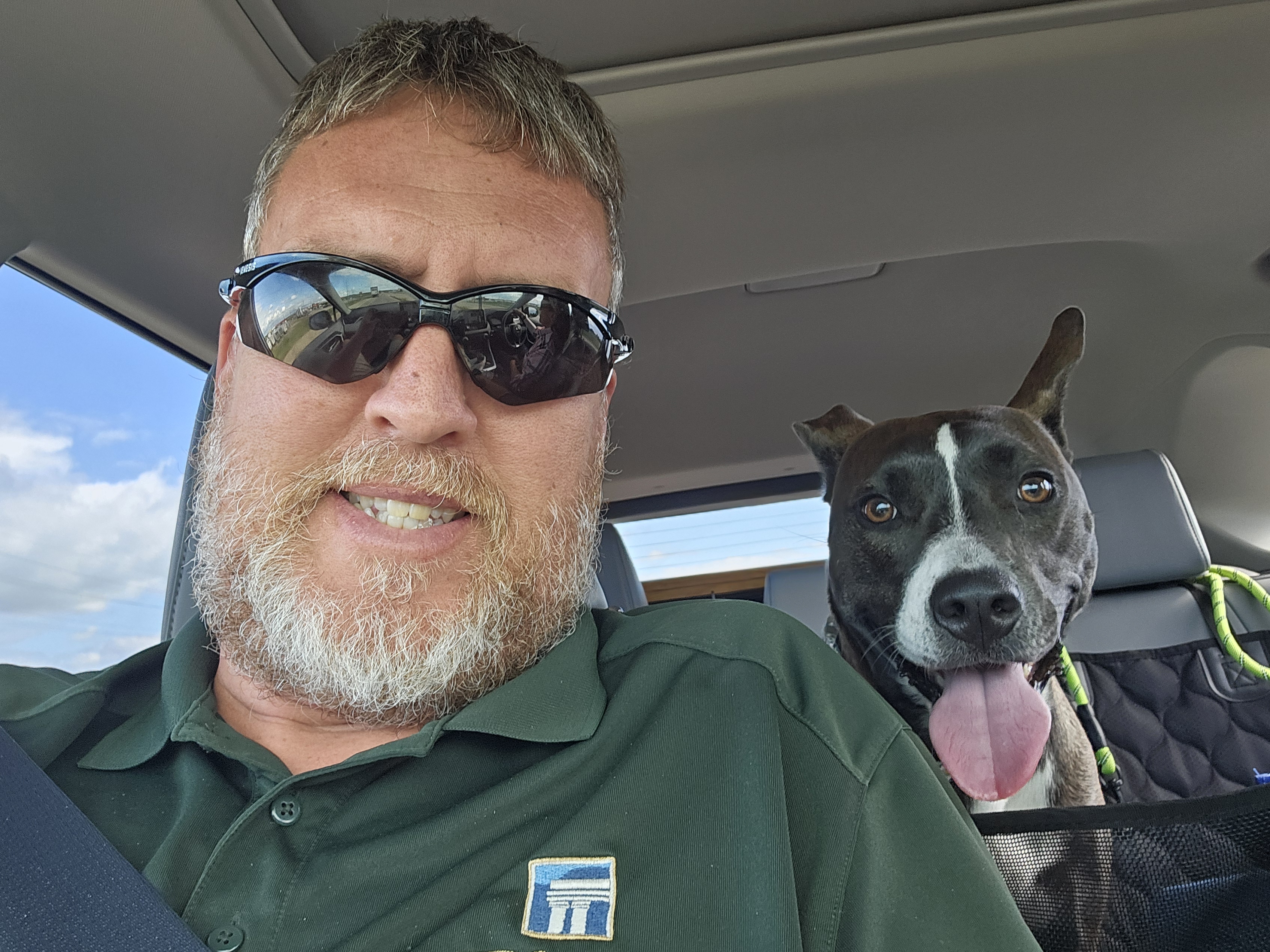 Josh inspecting a green with a Toro mower in the background